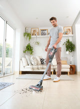 Η σκούπα stick BLACK+DECKER σε χρήση πάνω σε πλακάκια σε φωτεινό σαλόνι