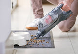 Η BLACK+DECKER σε λειτουργία σκούπας χειρός μαζεύει τροφή κατοικιδίου από πατάκι δίπλα σε μπολ