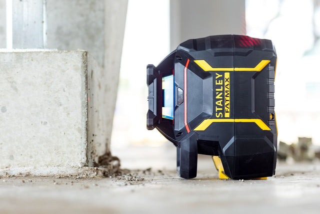 Περιστροφικό αλφάδι laser STANLEY FATMAX RL600 σε πλάγια όψη, τοποθετημένο στο δάπεδο εργοταξίου